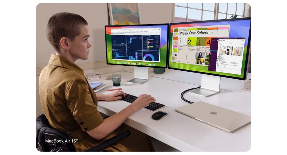 Person working at two external display screens that are connected to a closed 15-inch MacBook Air in Starlight finish